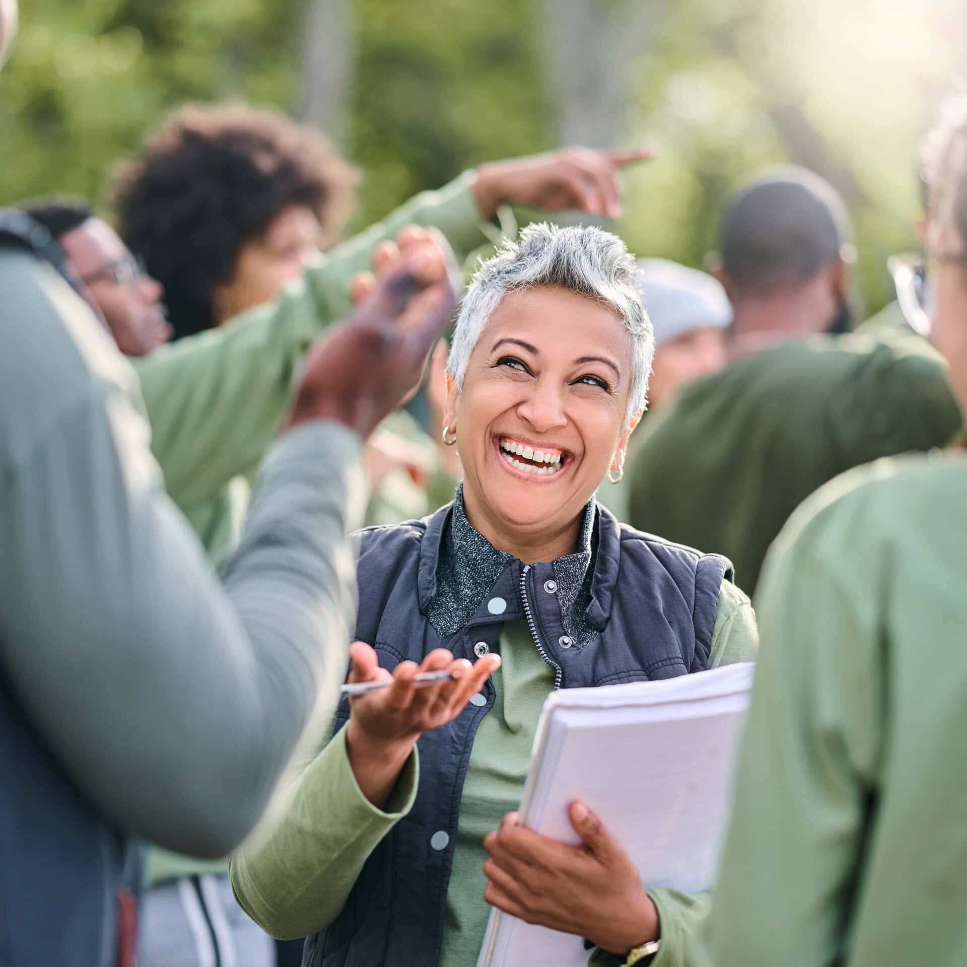 Smiling woman talking in group outdoors.
