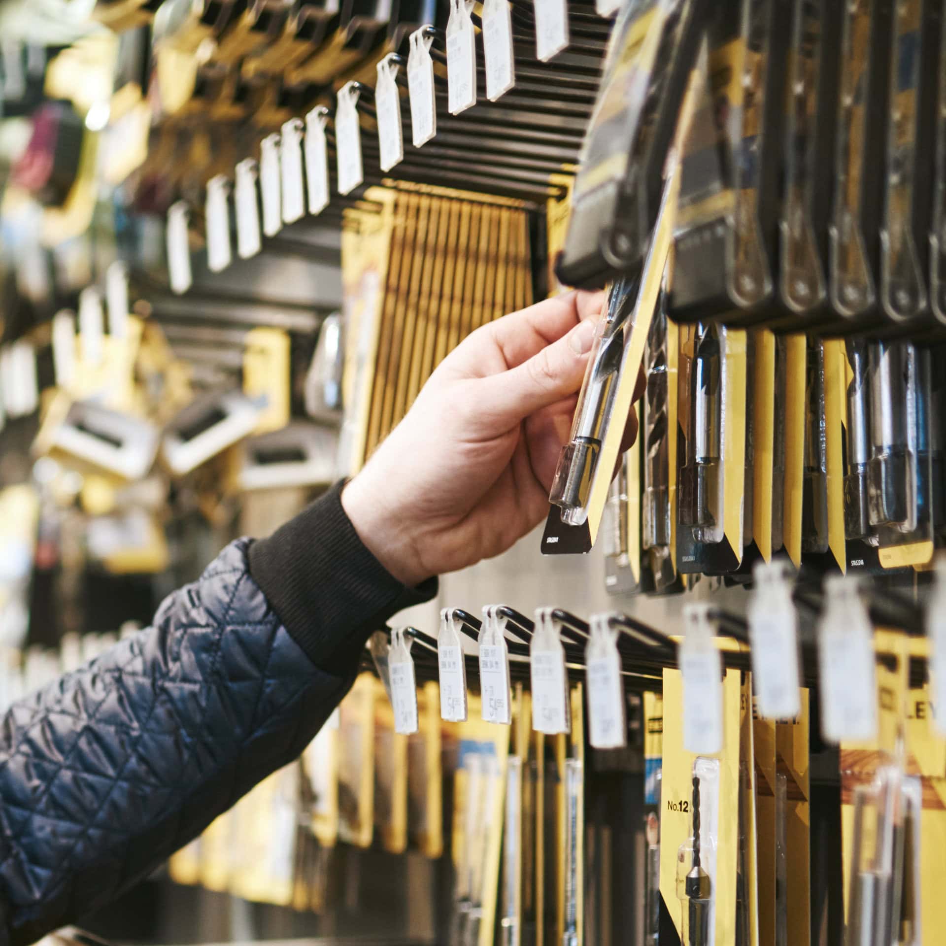 Person shopping for hardware tools in store.